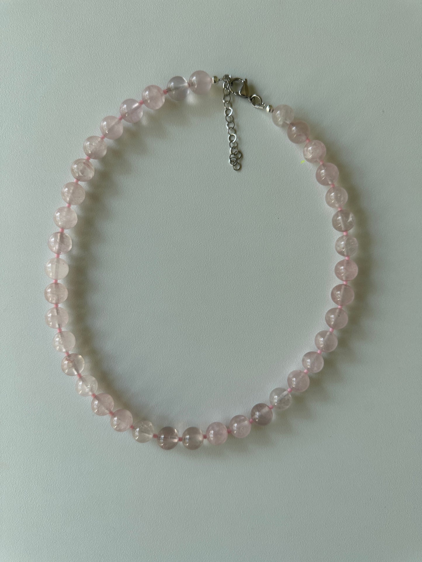Pink beaded bracelet on a light gray background