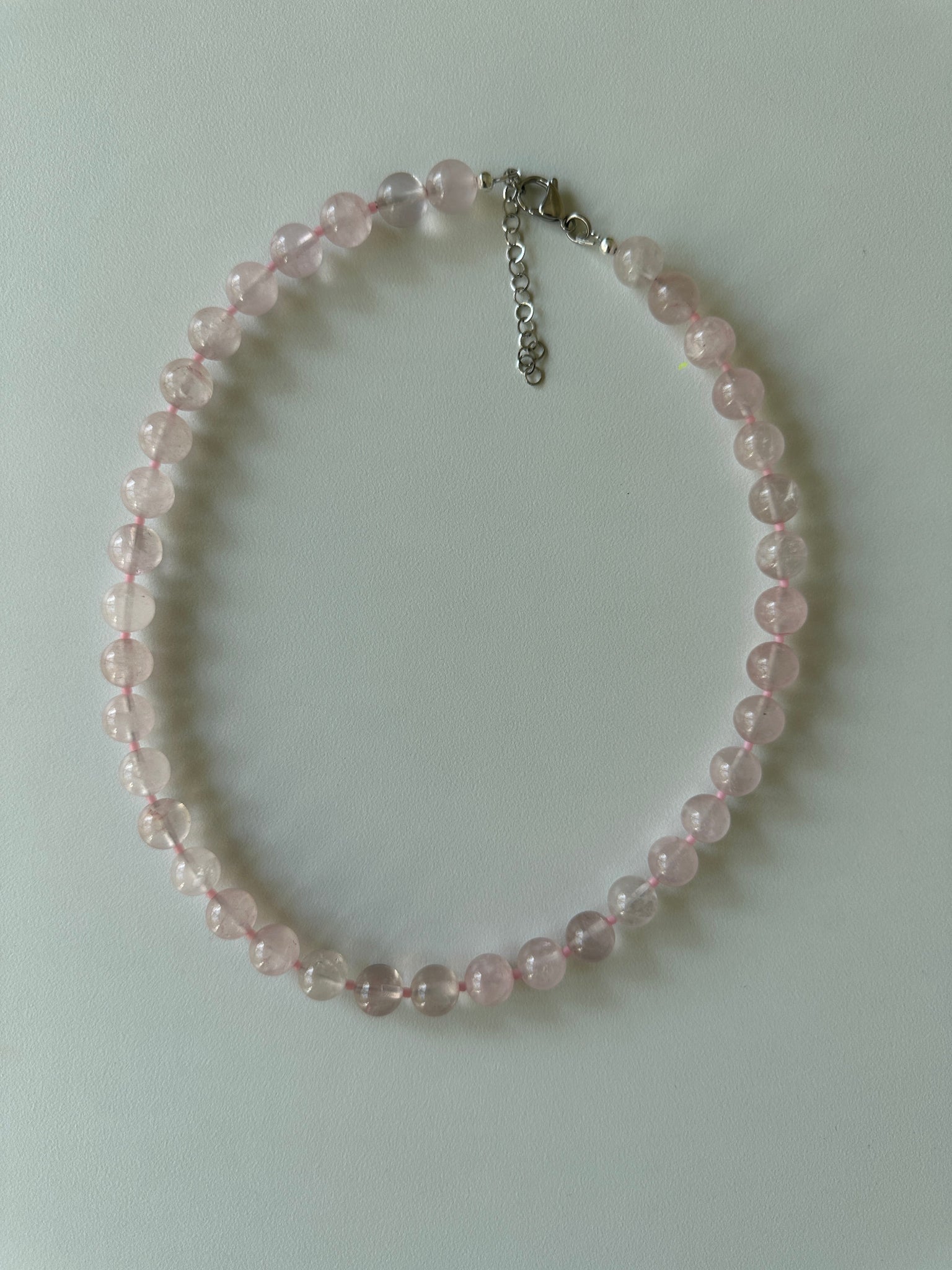 Pink beaded bracelet on a light gray background