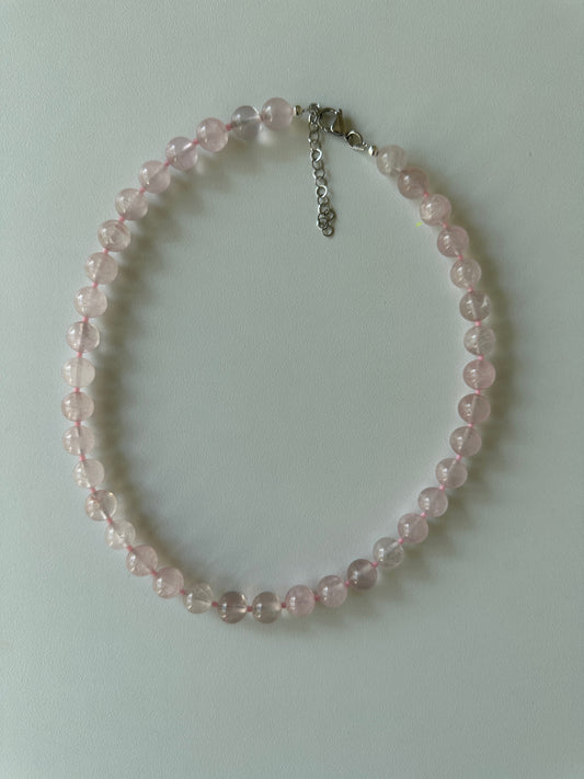 Pink beaded bracelet on a light gray background